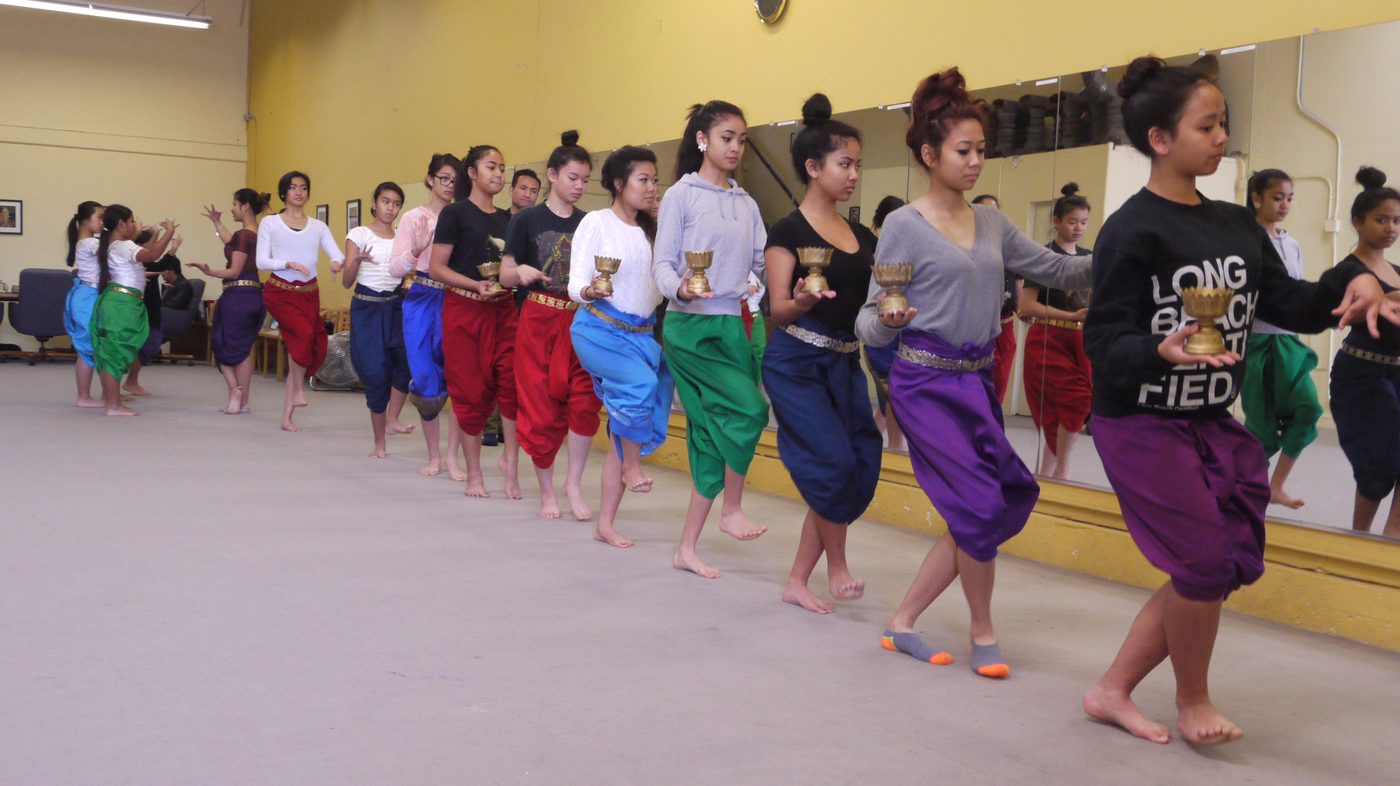 Line of Khmer classical dancers rehearsing in colorful silk sampots