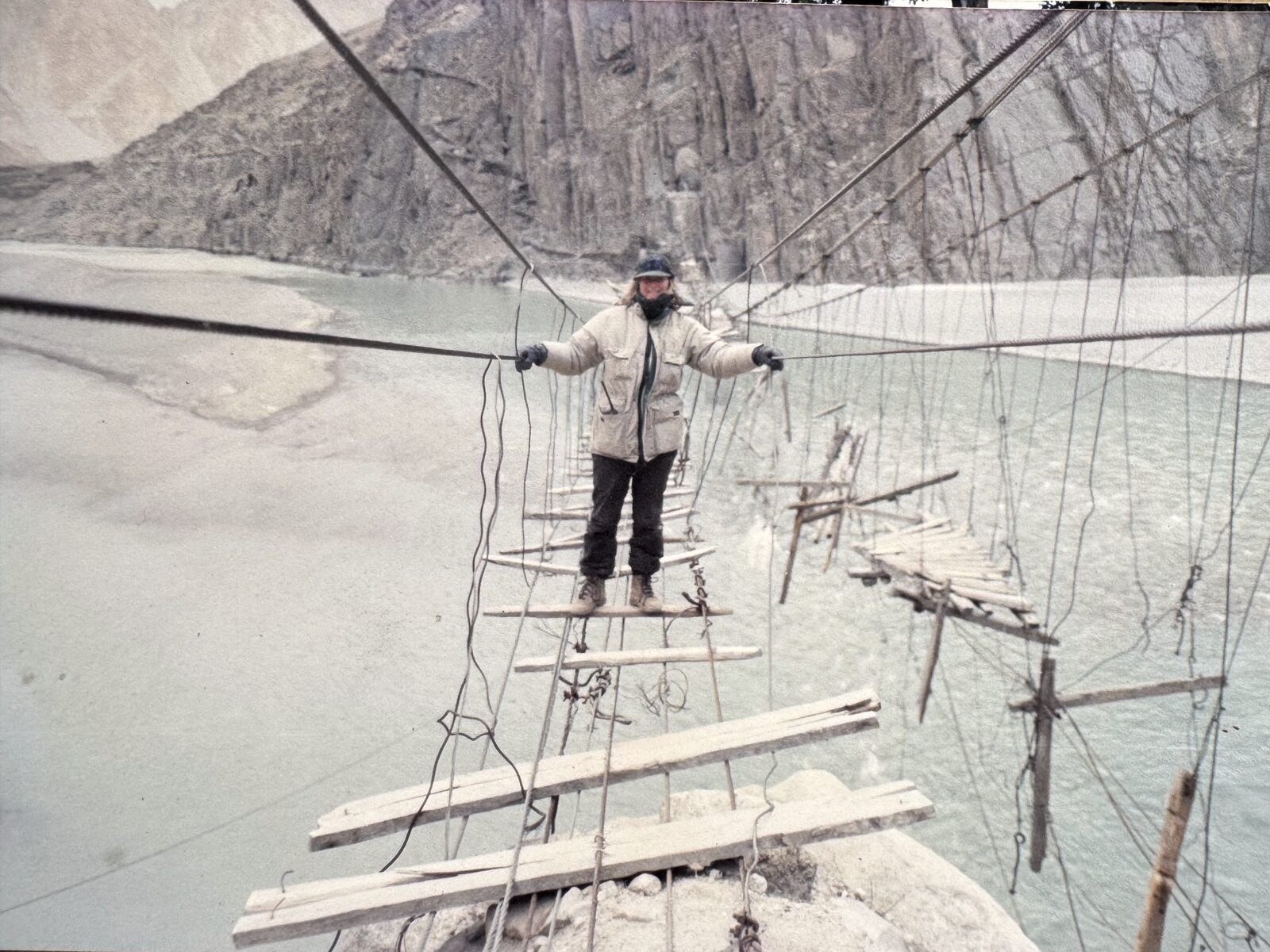 Crossing a broken suspension bridge over a glacial river